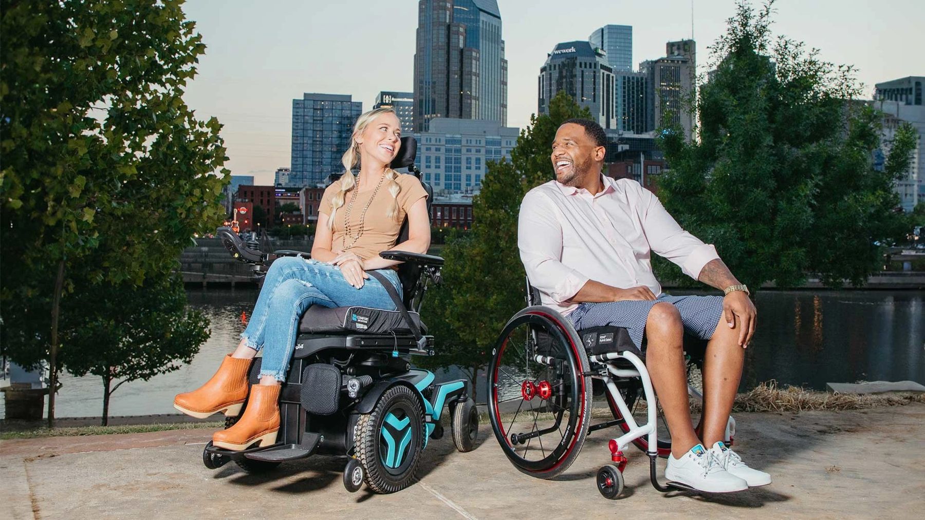 Friends on a city waterfront, one in a Permobil power wheelchair